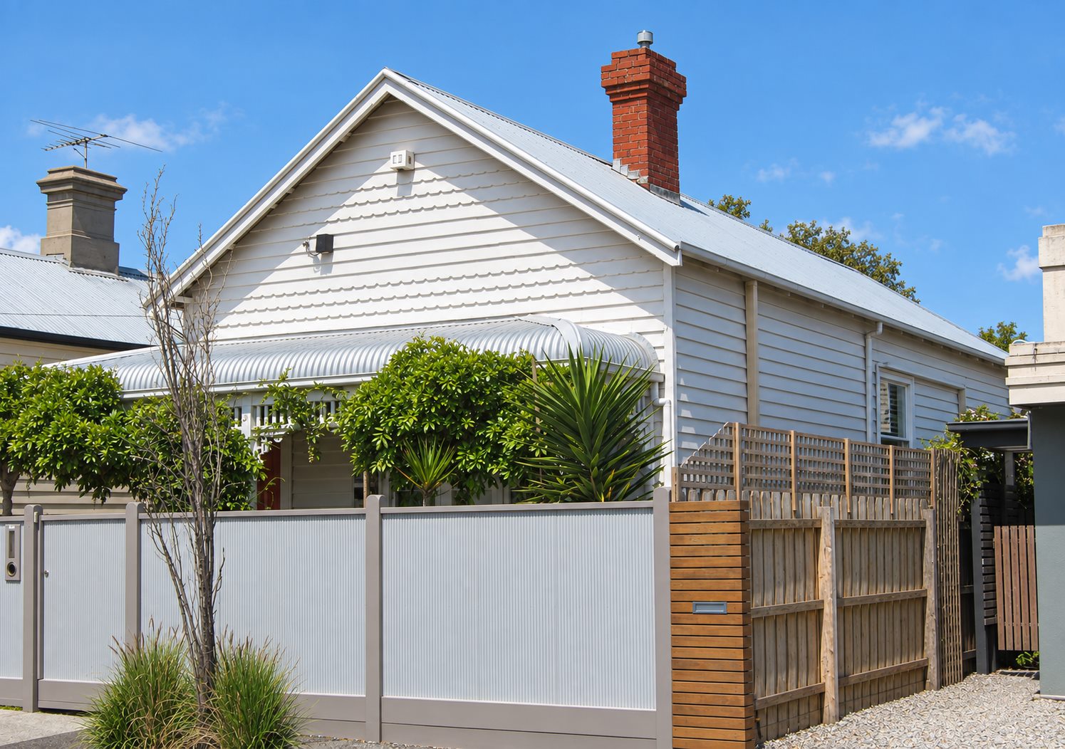 The existing cottage from the street, weatherboard gable and bullnose verandah