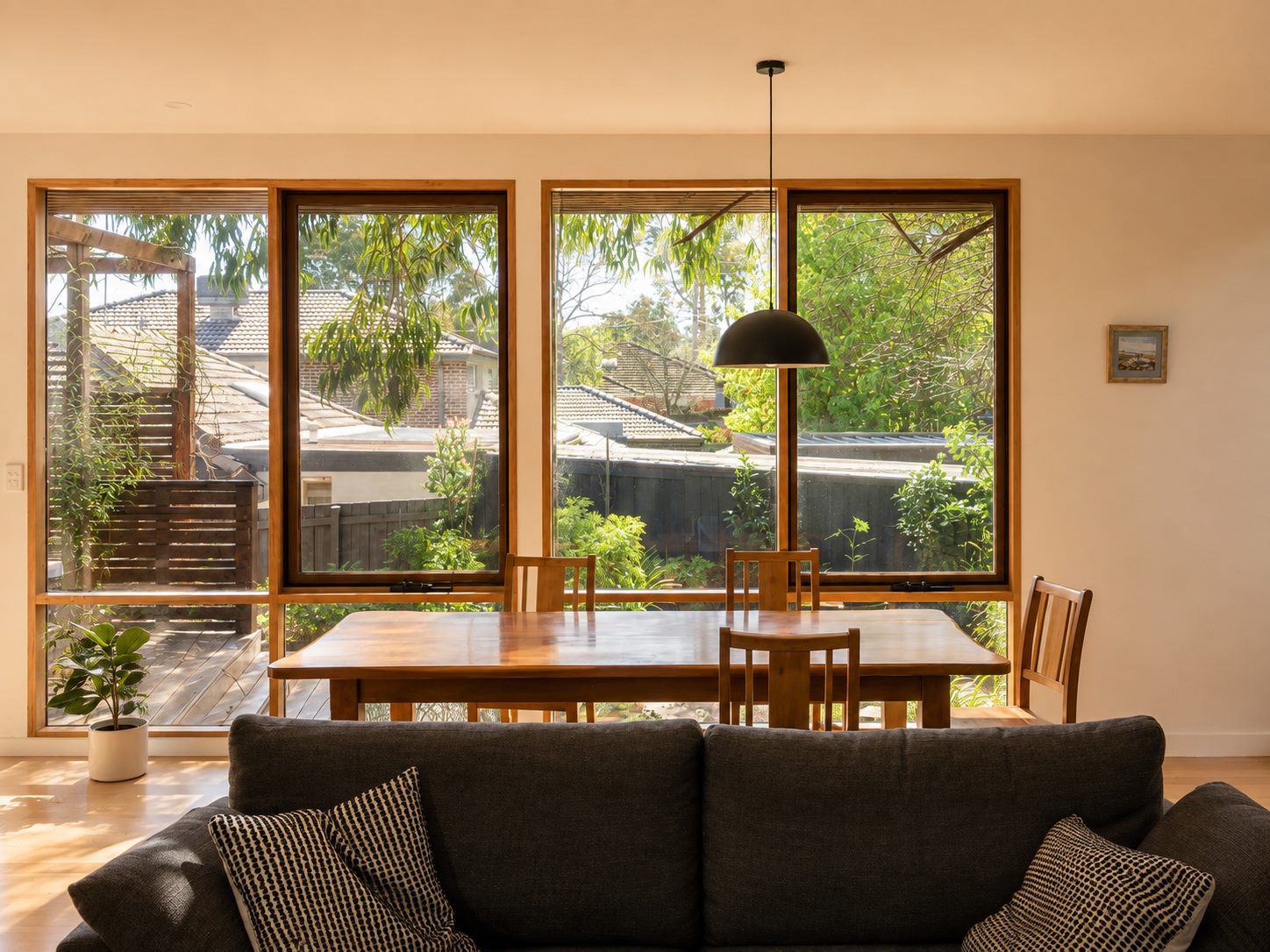 The dining table under a run of timber-framed windows onto the garden