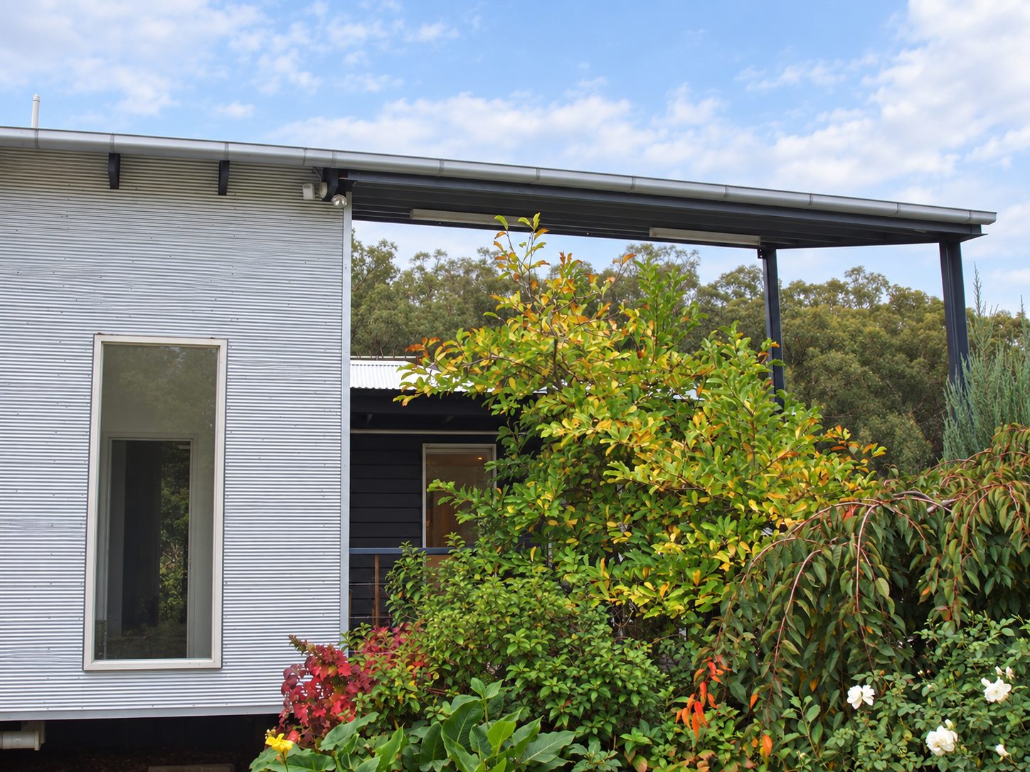 The steel frame from the garden, with the mini orb clad box and its tall slot window