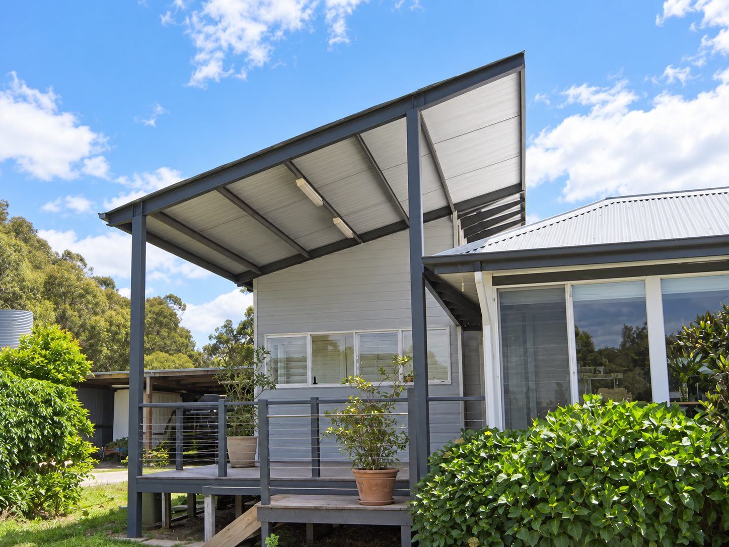 The house from the garden, the verandah roof carried out over the deck on a steel frame