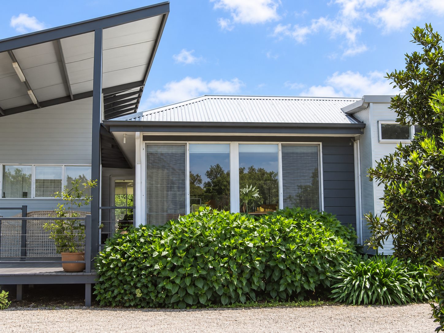 The glazed wing beside the verandah, corrugated roof and mini orb cladding